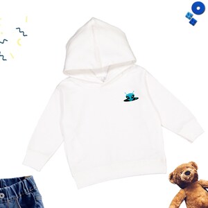 May include: White hooded sweatshirt with a blue alien peeking out of a hole on the front.
