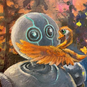 May include: A grey robot with teal accents and large blue eyes is holding a small orange bird with green eyes. The robot is in a forest setting with a blurred background of trees and flowers.