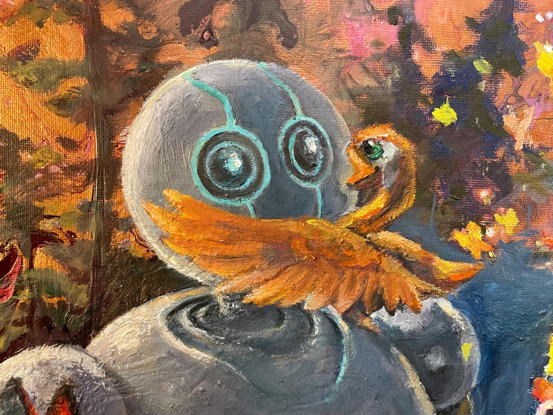 May include: A grey robot with teal accents and large blue eyes is holding a small orange bird with green eyes. The robot is in a forest setting with a blurred background of trees and flowers.