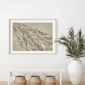 May include: A framed print of an abstract design featuring a flowing pattern of green and brown leaves on a light green background. The print is displayed on a white wall above a white bench with three woven baskets.