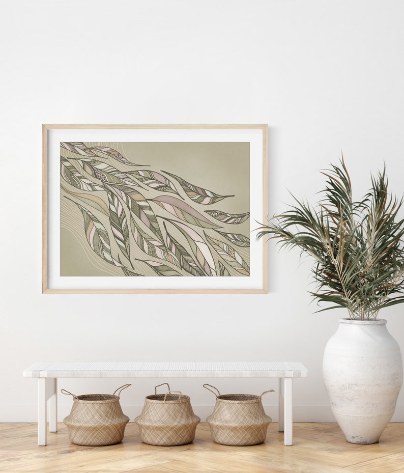 May include: A framed print of an abstract design featuring a flowing pattern of green and brown leaves on a light green background. The print is displayed on a white wall above a white bench with three woven baskets.