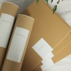 May include: Three brown cardboard boxes with white labels that say "The Doodle Box". Two of the boxes are rolled into tubes.