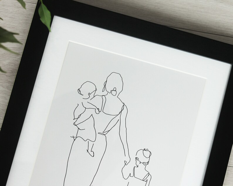 K&ouml;nnte beinhalten: Gerahmter Kunstdruck mit einer minimalistischen Strichzeichnung einer Mutter und zwei Kindern. Das Kunstwerk ist eine durchgehende schwarze Linie auf wei&szlig;em Hintergrund, die ein einfaches Familienportr&auml;t ergibt. Der Rahmen ist schwarz.