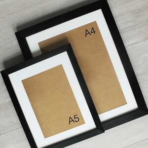 May include: Two black picture frames with white mats. The larger frame is labeled "A4" and the smaller frame is labeled "A5".