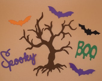 Pode incluir: Decorações temáticas de Halloween com uma silhueta de árvore castanha, morcegos roxos, laranja e pretos, e as palavras "Spooky" e "Boo" em roxo e verde. Perfeito para artesanato e decoração sazonal.