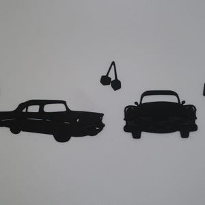 Puede incluir: Un conjunto de piezas de decoraci&oacute;n de pared negras que incluyen la silueta de un coche cl&aacute;sico visto de lado, una silueta de coche cl&aacute;sico de frente, dos flechas direccionales apuntando hacia adentro y una silueta de cerezas.