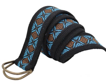 May include: A black woven belt with a blue and brown geometric pattern. The belt has a double D-ring buckle.