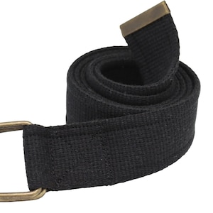 Pode incluir: Um cinto de lona preto com uma fivela de lat&atilde;o e um anel em D. O cinto est&aacute; enrolado e a fivela &eacute; vis&iacute;vel.