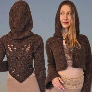 May include: A brown crocheted hooded sweater with a cropped length and bell sleeves. The sweater features a delicate openwork design on the back.