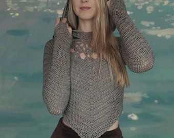 May include: A gray crocheted hooded top with long sleeves and a unique openwork design around the neckline. The top is paired with a brown skirt. The outfit is a unique handmade design.