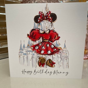 K&ouml;nnte beinhalten: Eine Gru&szlig;karte mit einer Cartoon-Illustration von Minnie Mouse in einem rot-wei&szlig; gepunkteten Kleid, die vor dem Schloss von Aschenputtel steht. Die Karte tr&auml;gt den Text "Happy Birthday Mummy".