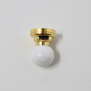 May include: A gold ceiling light fixture with a white globe shade.