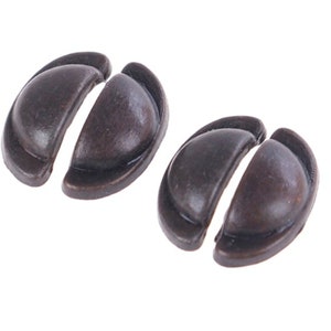 May include: Two antique-style, half-round cabinet door pulls in a dark bronze finish. Each pull is made of two separate pieces that fit together.
