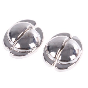 May include: Two silver-toned metal beads with a smooth, rounded surface. Each bead is split in half, creating a unique design.