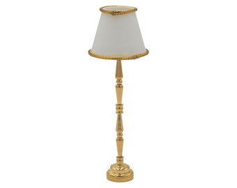 May include: A gold floor lamp with a white lampshade and a gold trim. The lamp has a classic design with a round base and a tall, slender stem.