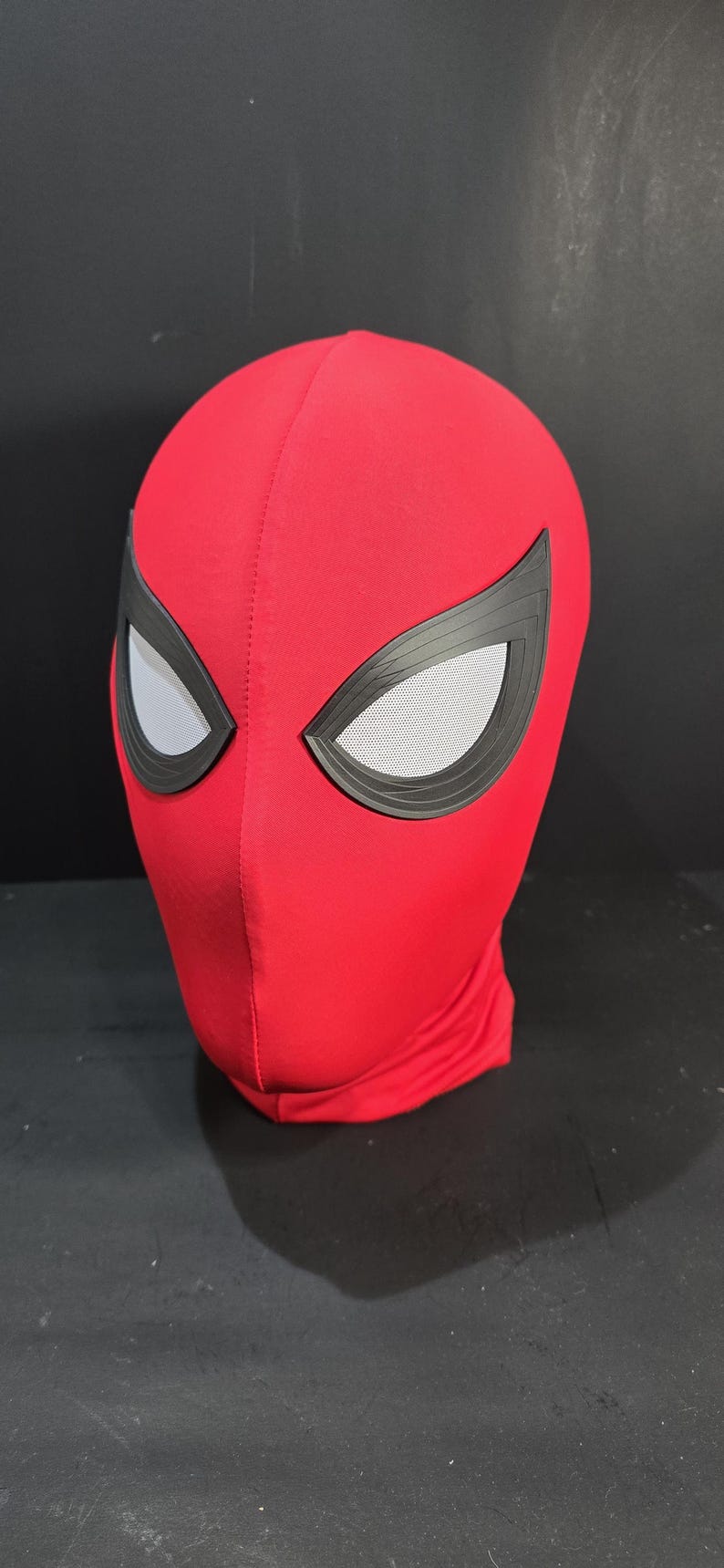 May include: Red Spiderman mask with black eye frames and mesh eye coverings. The mask is made of a smooth, stretchy material and is designed to cover the entire head. A costume accessory.