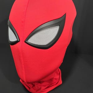 May include: A red Spider-Man mask with black eye frames and white mesh eye coverings. The mask is made of a soft, flexible material and covers the entire head and neck. The mask is a cosplay item.