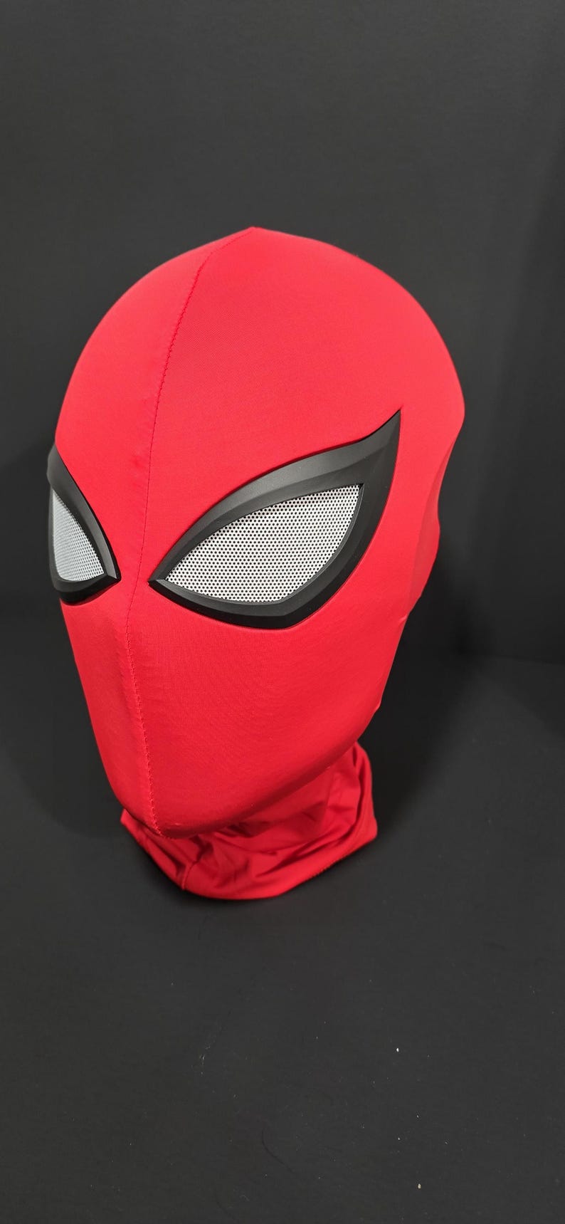 May include: A red Spider-Man mask with black eye frames and white mesh eye coverings. The mask is made of a soft, flexible material and covers the entire head and neck. The mask is a cosplay item.
