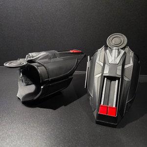 Puede incluir: Un par de lanzatelara&ntilde;as negros y rojos, un accesorio popular para los fan&aacute;ticos de los superh&eacute;roes. Los lanzatelara&ntilde;as tienen un dise&ntilde;o detallado con un patr&oacute;n negro y plateado y detalles rojos.