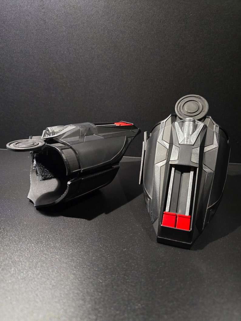 Puede incluir: Un par de lanzatelara&ntilde;as negros y rojos, un accesorio popular para los fan&aacute;ticos de los superh&eacute;roes. Los lanzatelara&ntilde;as tienen un dise&ntilde;o detallado con un patr&oacute;n negro y plateado y detalles rojos.