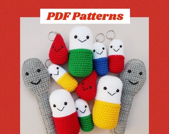May include: A collection of crocheted amigurumi toys in the shape of pills, spoons, and a teardrop. The toys are all different colors, including red, green, yellow, blue, and gray. The toys have smiling faces and are made with a variety of stitches. The image includes the text "PDF Patterns" and "CraftWithCrohns".