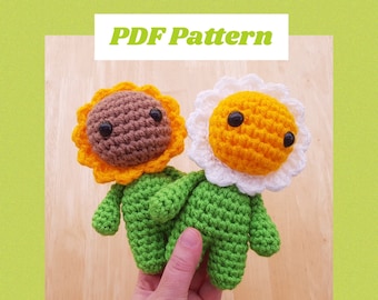 May include: Two crocheted sunflower plushies with green stems and leaves. One has a brown center and yellow petals, the other has a yellow center and white petals. The text "PDF Pattern" is at the top.