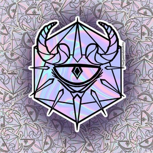 May include: A holographic sticker featuring a black outline of a single eye with horns and a diamond shape at its centre. The eye is enclosed within a geometric shape with spikes. The sticker has an iridescent background.