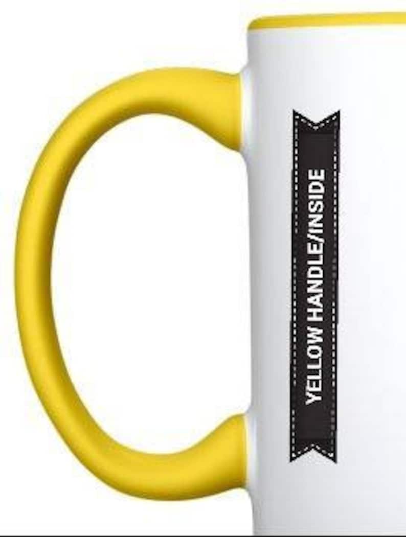 May include: White ceramic mug with a yellow handle and rim. The mug has a black banner with the text "Yellow Handle/Inside" printed on it.
