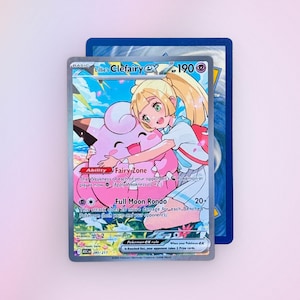 May include: A Lillie's Clefairy ex trading card with 190 HP, featuring an illustration of a character hugging a pink Clefairy. The card text includes the Fairy Zone ability and Full Moon Rondo attack, with a blue border and a 280/217 set number.