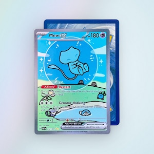 May include: A Mew ex Pokémon trading card featuring a light blue illustration of Mew inside a circular bubble against a sky blue and green landscape. The card displays the text Mew ex, 180 HP, Ability Restart, Genome Hacking, and Pokémon ex rule.