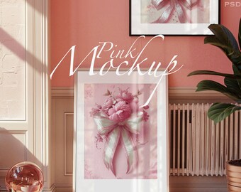 May include: A white picture frame with a pink floral print of a bouquet of pink roses with a white ribbon bow. The frame is on a pink wall with a white window frame and a green plant in a brown pot.