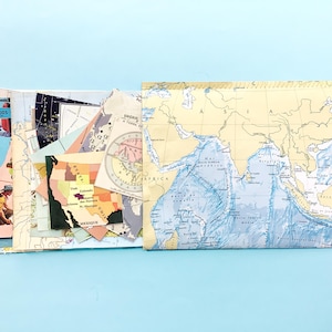 May include: A collection of assorted paper map fragments featuring various geographic regions, including a prominent map of Asia, a section of the United States with the text 'Mexique', and a vintage-style circular map illustration.
