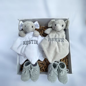 personalised newborn twin gift, includes two elephant comforters personalised and wool knitted baby booties. Choose from pink, white, grey or blue colour options. dark grey named embroidery. baby twin arrival gift.