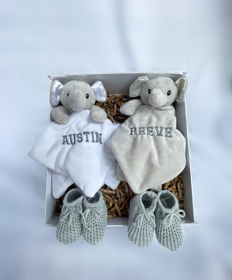 personalised newborn twin gift, includes two elephant comforters personalised and wool knitted baby booties. Choose from pink, white, grey or blue colour options. dark grey named embroidery. baby twin arrival gift.