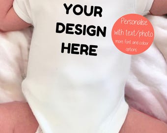 May include: White baby onesie with the text "YOUR DESIGN HERE" in black. A red circle with the text "Personalise with text/photo more font and colour options" is in the upper right corner.