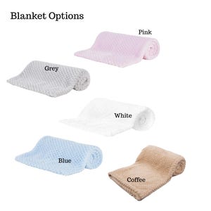 May include: A selection of soft, textured blankets in various colors, including grey, pink, white, blue, and coffee. Each blanket is folded and rolled, showcasing the different color options available. The text "Blanket Options" is at the top.