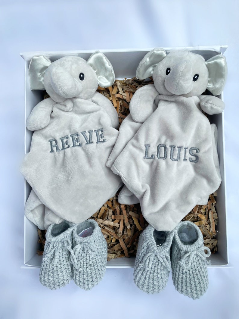 personalised newborn twin gift, includes two elephant comforters personalised and wool knitted baby booties. Choose from pink, white, grey or blue colour options. dark grey named embroidery. baby twin arrival gift.