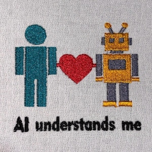 Könnte beinhalten: Gesticktes Design auf weißem Stoff mit einer türkisfarbenen Figur, einem goldenen Roboter und einem roten Herzen. Der Text "AI understands me" ist darunter in Schwarz gestickt. Das Design hat eine skurrile, technikbezogene Ästhetik.