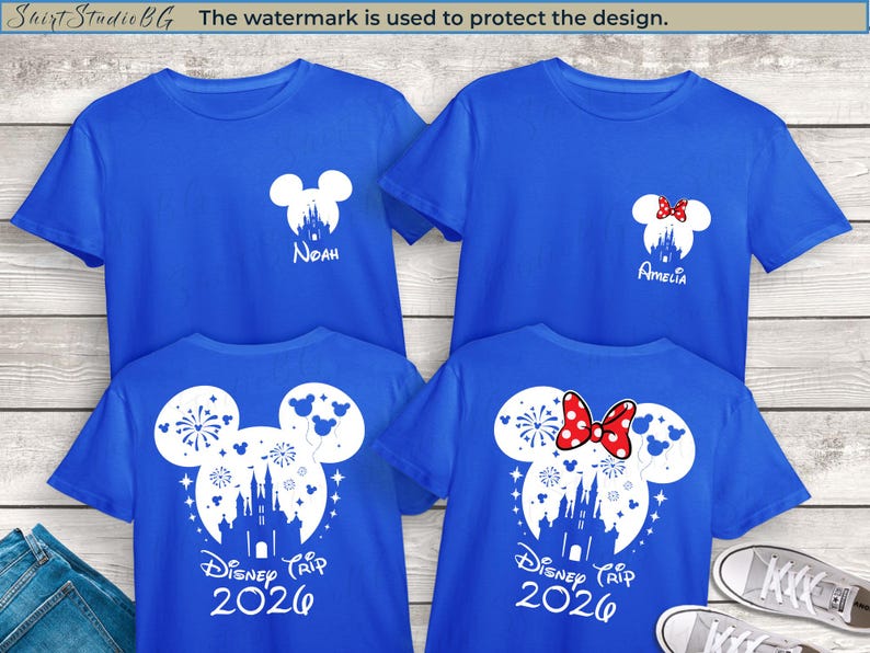 Peut inclure: Quatre t-shirts bleus avec des motifs graphiques blancs. Deux chemises pr&eacute;sentent une t&ecirc;te de Mickey Mouse avec une silhouette de ch&acirc;teau et le texte "Disney Trip 2026". Les deux autres chemises ont une t&ecirc;te de Mickey Mouse avec les noms "Noah" et "Amelia".