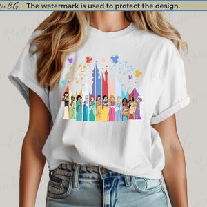 May include: White t-shirt featuring a colorful graphic of various princesses standing in front of a castle silhouette. The design includes fireworks and balloons. The text "Shirt StudioBG The watermark is used to protect the design." is at the top.