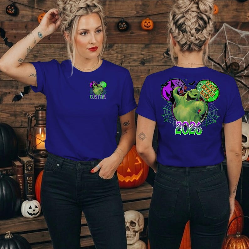Puede incluir: Una camiseta azul real con un peque&ntilde;o gr&aacute;fico verde de Oogie Boogie en el pecho izquierdo con el texto CUSTOM. La parte posterior muestra un gran personaje verde de Oogie Boogie, una telara&ntilde;a y el texto OOGIE BOOGIE BASH 2026 en verde brillante.