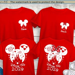 Peut inclure: T-shirts rouges avec des motifs Disney blancs. Deux chemises pr&eacute;sentent une t&ecirc;te de Mickey Mouse avec un ch&acirc;teau et le nom "Noah". Deux autres ont une t&ecirc;te de Minnie Mouse avec un n&oelig;ud et le nom "Amelia". Les chemises du bas indiquent "Disney Trip 2026".