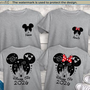 Peut inclure: Quatre t-shirts gris avec des motifs de t&ecirc;te de Mickey Mouse noirs. Deux chemises portent les noms "Noah" et "Amelia" sous la t&ecirc;te. Les deux autres chemises indiquent "Disney Trip 2026" avec un ch&acirc;teau et des feux d'artifice.