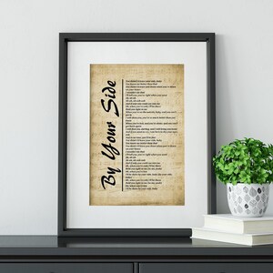 May include: A framed print of the song lyrics for "By Your Side" by Rascal Flatts. The lyrics are printed on a vintage-style sheet music background.