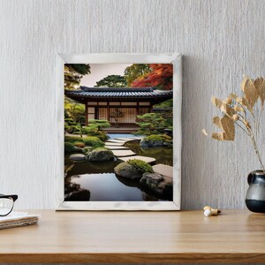 May include: A framed photograph of a Japanese garden with a traditional wooden house, a pond, and a stone path. The house has a wooden door and windows, and the pond is surrounded by green plants and trees.