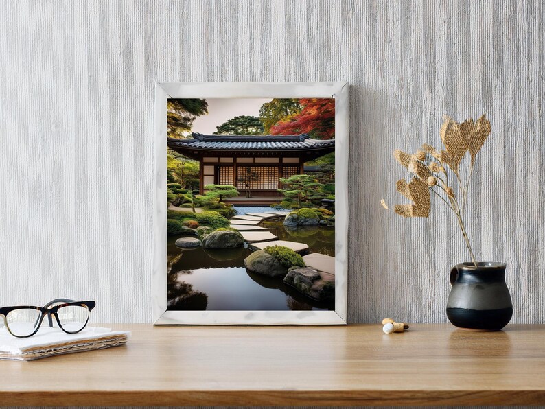 May include: A framed photograph of a Japanese garden with a traditional wooden house, a pond, and a stone path. The house has a wooden door and windows, and the pond is surrounded by green plants and trees.
