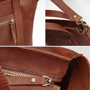 A close-up view of a brown leather handbag, showcasing its detailed features such as the zipper, straps, and hardware.