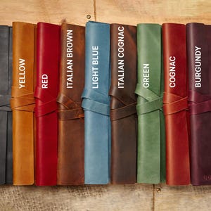 Peut inclure: Dix journaux reli&eacute;s en cuir de diff&eacute;rentes couleurs, dont noir, jaune, rouge, brun italien, bleu clair, cognac italien, vert, cognac et bordeaux. Chaque journal est dot&eacute; d'une fermeture &agrave; sangle en cuir.