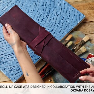 Peut inclure: Un &eacute;tui enroulable en cuir bordeaux pour fournitures artistiques. L'&eacute;tui est enroul&eacute; et attach&eacute; avec une sangle en cuir bordeaux. L'&eacute;tui est con&ccedil;u en collaboration avec l'artiste Oksana Dobrytsya.