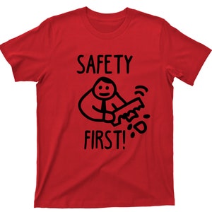 Puede incluir: Camiseta roja con una ilustración negra de una persona sosteniendo una sierra y el texto "SAFETY FIRST!"